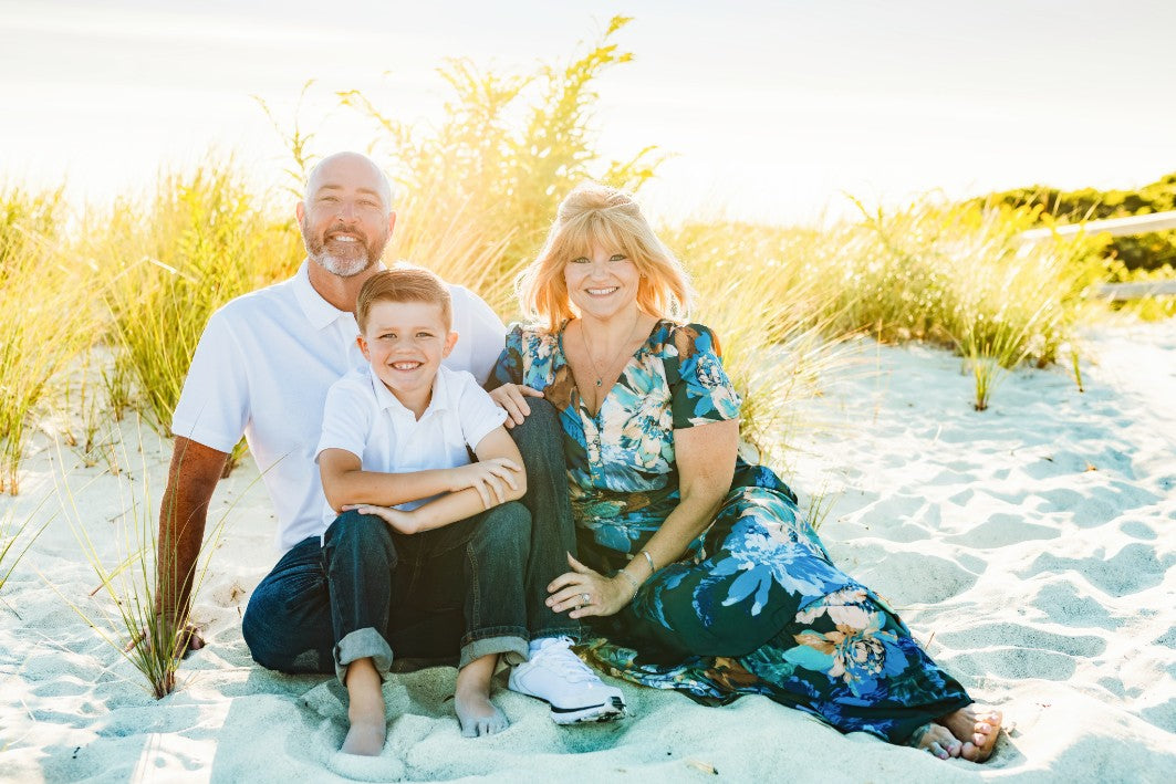 Rich, a stroke survivor, sits with his family for pictures of the beach. 
